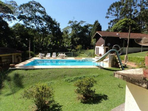 a swimming pool with a slide in a yard at Abaete Pousada da Estancia in São Roque
