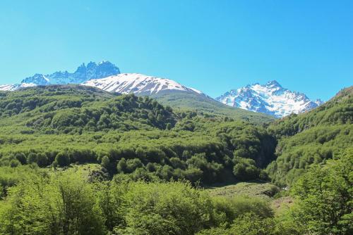 a valley with snow covered mountains and trees at Casa Cerro Castillo in Villa Cerro Castillo