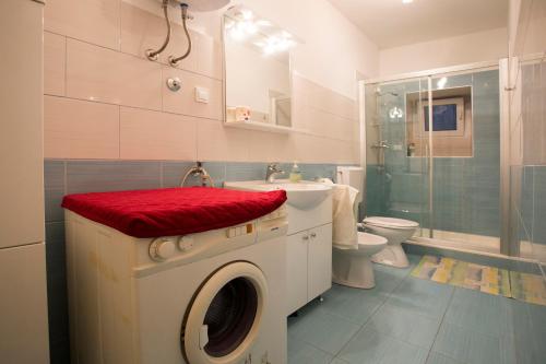 een badkamer met een wasmachine en een wastafel bij Apartment Pera in Split