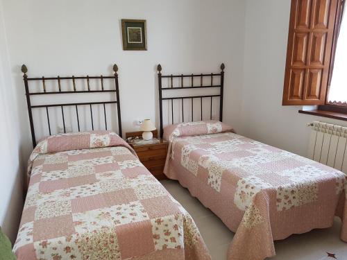 two beds sitting next to each other in a bedroom at El Pedroso in Santillana del Mar