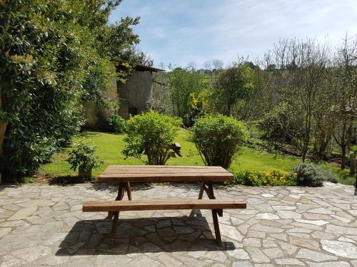 a wooden picnic bench sitting on a stone patio at El Pedroso in Santillana del Mar