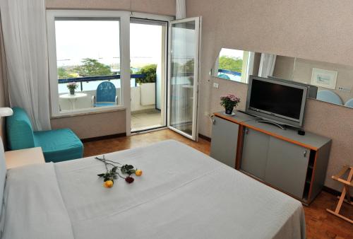 a hotel room with a bed and a tv and a room at Hotel Venere in Cesenatico