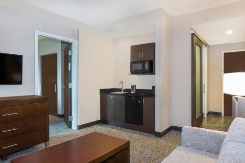 a hotel room with a kitchen and a living room at Wingate by Wyndham Miami Airport in Miami