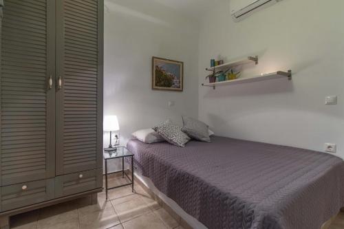 a bedroom with a bed and a table with a lamp at Alma Libre Villas in Kastraki Naxou
