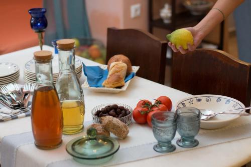 a person holding a lemon on a table with food at Alma Libre Villas in Kastraki Naxou