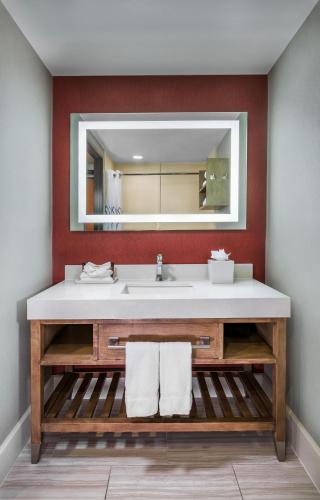 a bathroom with a sink and a mirror at Desert Palms Hotel & Suites Anaheim Resort in Anaheim