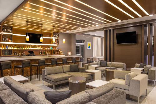 a hotel lobby with couches and a bar at Wingate by Wyndham Miami Airport in Miami