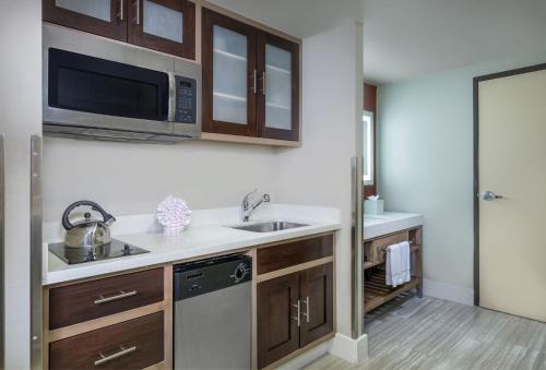 a kitchen with a sink and a microwave at Desert Palms Hotel & Suites Anaheim Resort in Anaheim