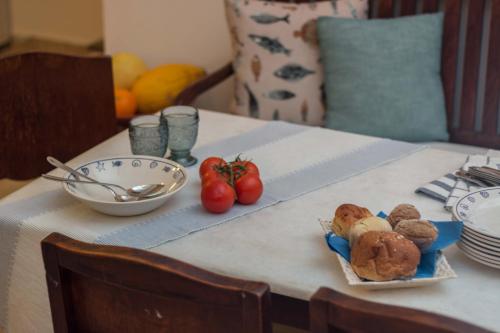 a table with a plate of food and a bowl of tomatoes at Alma Libre Villas in Kastraki Naxou