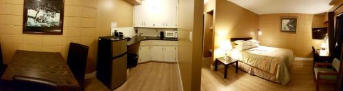 a small room with a bed and a kitchen at Above Tide Motel in Campbell River