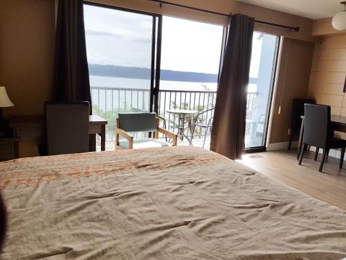a bedroom with a bed and a view of the ocean at Above Tide Motel in Campbell River