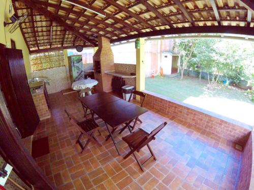 a patio with a table and chairs on a brick floor at Trindade Casa Amarela in Trindade