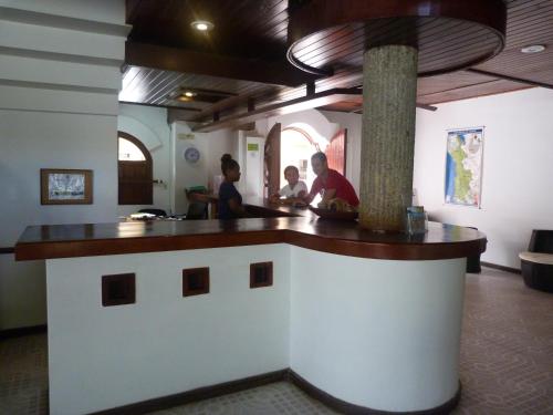 two people sitting at a counter in a restaurant at Hotel Costa Choco in Bahía Solano