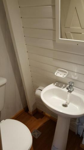 y baño con lavabo blanco y aseo. en Villa El Radal en San Martín de los Andes