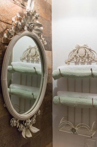 a mirror on a wall with green towels at Alma Libre Villas in Kastraki Naxou