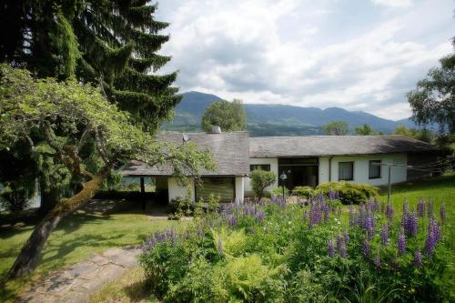 a house with a garden with purple flowers at Waldstrand Berger in Seeboden