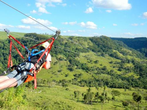 a person riding a zip line in the sky at Pousada Alvorada Brotas - e agendamento das atividades turísticas in Brotas