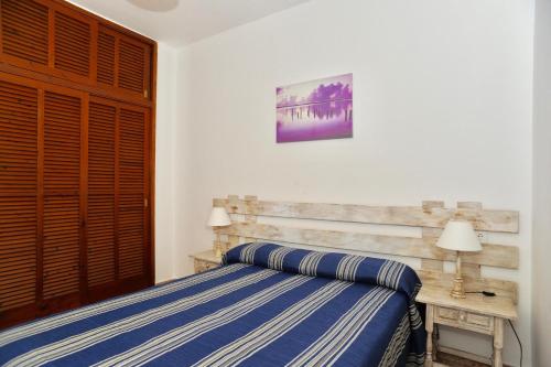 1 dormitorio con 1 cama y puerta de madera en Viviendas Turisticas S'Estanyol, en La Savina