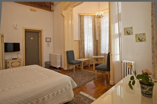 sypialnia z łóżkiem, stołem i krzesłami w obiekcie Vila Camelia w mieście Sinaia