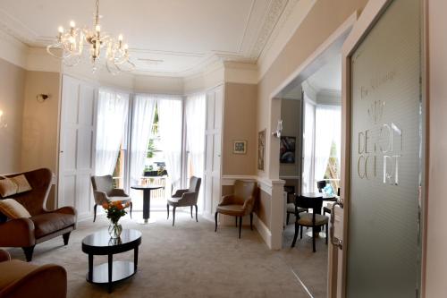 a living room with a couch and chairs and a table at The Devon Court in Torquay