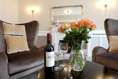 a bottle of wine and a vase of flowers on a table at The Devon Court in Torquay