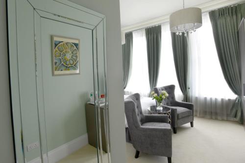 a room with two chairs and a mirror at The Devon Court in Torquay