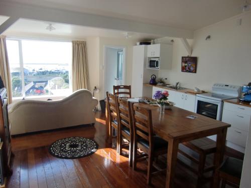 a kitchen and dining room with a table and chairs at Oamaru Green Cottage in Oamaru
