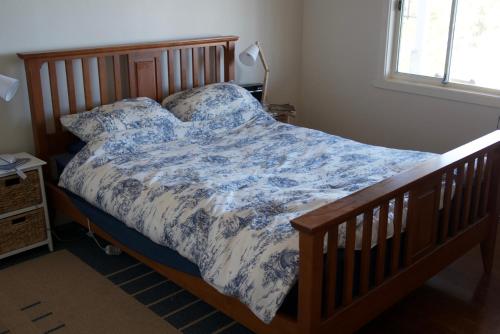 a bedroom with a bed with a blue and white comforter at Loutit Views in Lorne