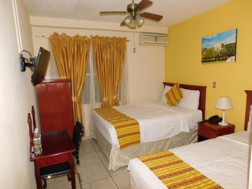 um quarto de hotel com duas camas e uma janela em Hotel San Jose Hostal em San Salvador