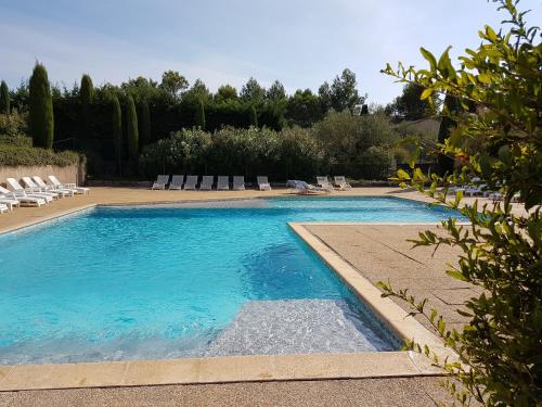 una grande piscina con sedie a sdraio in un cortile di Les Jasmins a Saint-Rémy-de-Provence