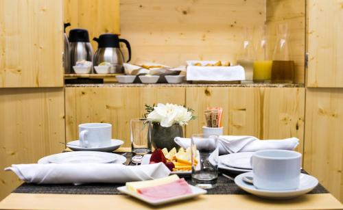 a table with white plates and dishes on it at Ribeiredge Guest House in Porto