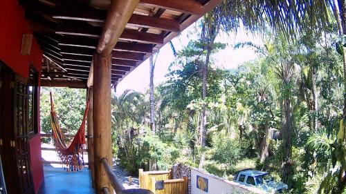 a porch of a house with a view of a forest at Mandacaru Chalés e Suítes Itamambuca in Ubatuba