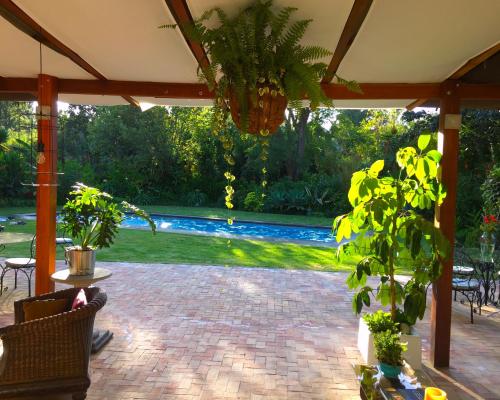 a patio with a pool in the background at Rukka Lodge in Tumbaco