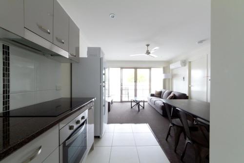 a kitchen with white cabinets and a black counter top at Rockhampton Serviced Apartments in Rockhampton