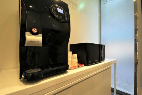 a microwave and a television sitting on a counter at Some Hotel in Busan