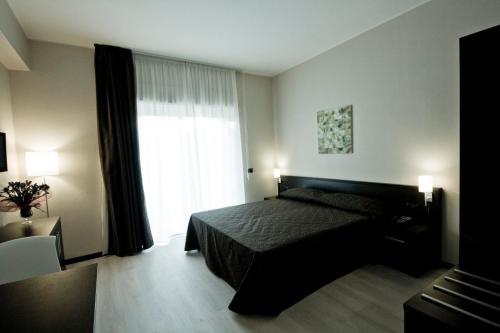 a bedroom with a bed and a large window at Guest House Residence in Messina