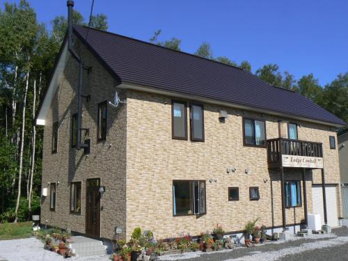 un grand bâtiment en briques avec un toit noir dans l'établissement Lodge Cowbell, à Kutchan