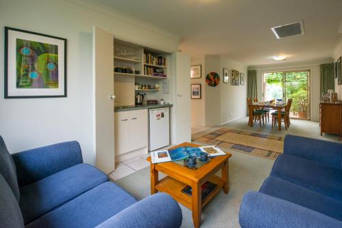 a living room with two blue chairs and a table at Bellevue Bed & Breakfast in McLaren Vale