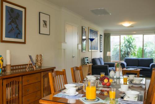 ein Esszimmer mit einem Tisch mit Speisen und Orangensaft in der Unterkunft Bellevue Bed & Breakfast in McLaren Vale