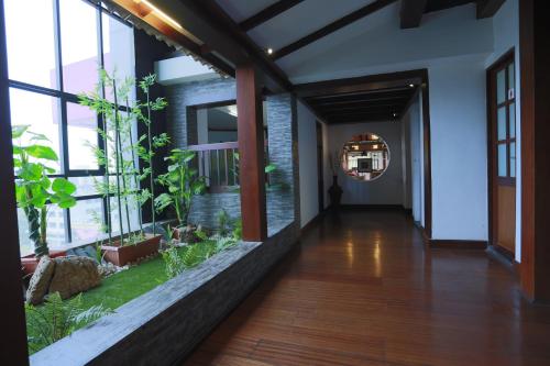a hallway with windows and plants in a building at Presidency Kochi City Centre in Cochin