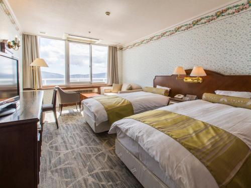 Habitación de hotel con 2 camas y TV en Hotel Mt. Fuji, en Yamanakako