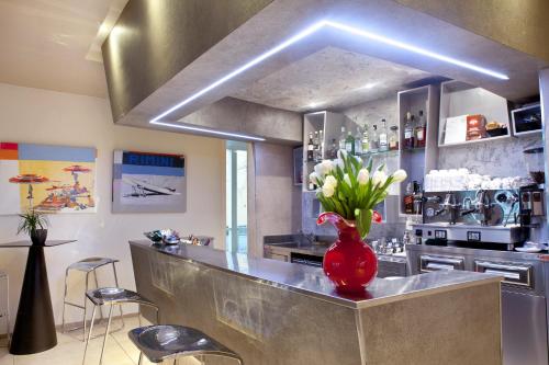 a kitchen with a counter with a vase of flowers at L'Hotel in Rimini