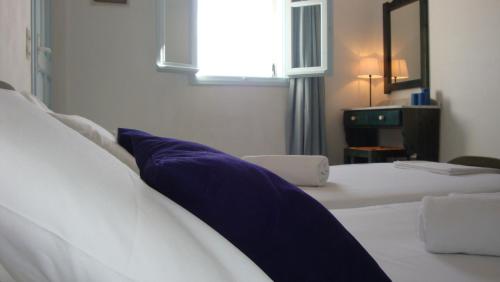 a bedroom with a white bed with a blue pillow at Blue & Sea Studios Apartments in Drios