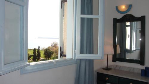 a bathroom with a window with a view of a field at Blue & Sea Studios Apartments in Drios