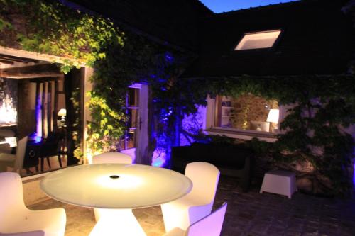 a white table and white chairs in a room at L'Hibernie in Rochefort-en-Yvelines