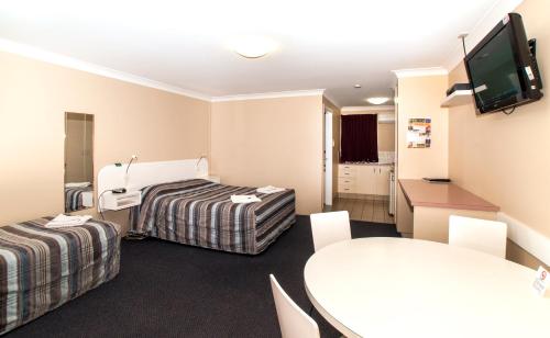 
a hotel room with two beds and a television at Jefferys Motel in Toowoomba
