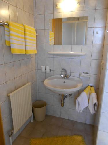 a bathroom with a sink and a mirror and towels at Haus Schweigl in Obsteig