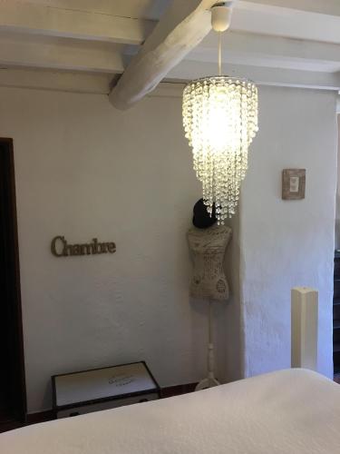 a room with a bed and a chandelier at chambres d hotes Le Mas Julien piscine chauffée adult only in Orange