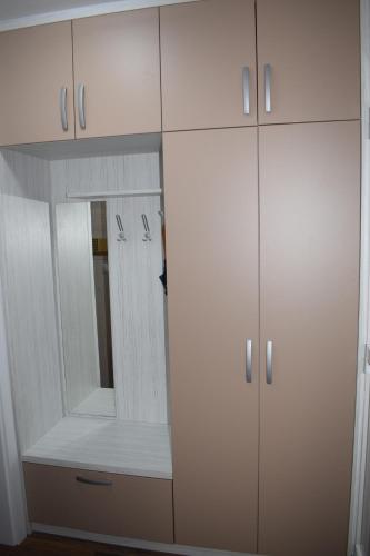 a white closet with a mirror and white cabinets at Borovnica Čatež in Čatež ob Savi