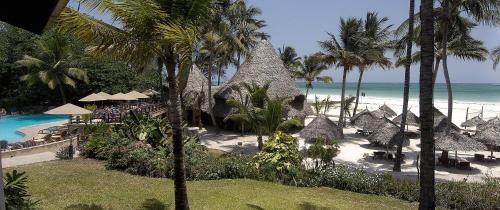 a resort with a pool and a beach with palm trees at Pinewood Beach Resort and Spa in Diani Beach